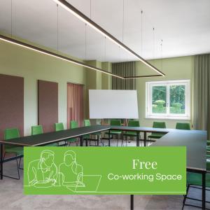 沙恩Kloster by b-smart的一间会议室,配有桌子和绿色椅子