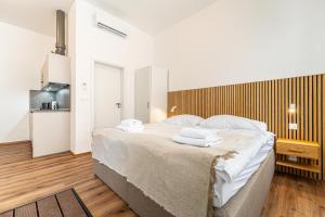 布尔诺Design Apartments Lužánky的一间卧室配有一张大床和毛巾