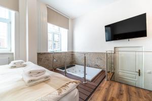 布尔诺Design Apartments Lužánky的带浴缸、床和电视的浴室