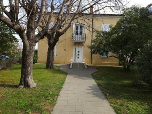 伊佐拉Depandansa Vista Parco, Izola的黄色的房子,有白色的门和树木