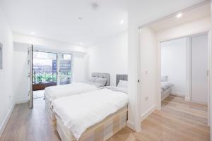 伦敦Heads on Bed- London Excel Royal Victoria Dock O2的白色的卧室设有床和窗户