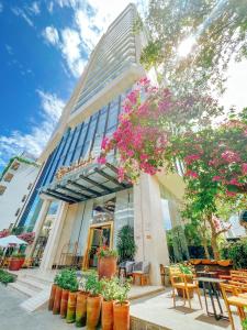 岘港Sala Danang Beach Hotel的一座配有桌椅和鲜花的建筑