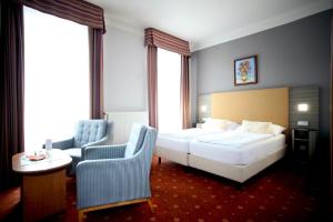 玛丽亚温泉帕里斯酒店的配有一张床和一把椅子的酒店客房