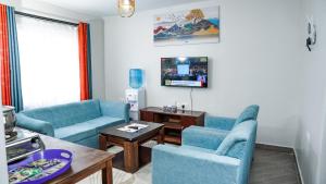奈瓦沙Kelly homes in Naivasha的客厅配有2把蓝色椅子和桌子