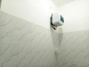BlimbingBebek Kuning Residence的白色瓷砖浴室的墙壁上配有肥皂机