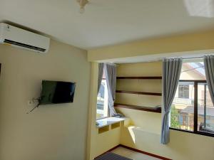 BlimbingBebek Kuning Residence的一间带电视和窗户的客厅