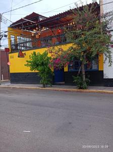 阿瓜斯卡连特斯Bonita casa en el corazón de la feria的黄色和黑色的建筑,在街上设有阳台