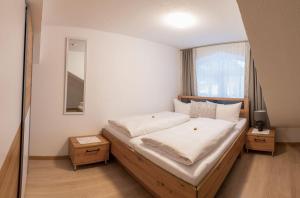 莱希河畔魏森巴赫Ferienwohnung Schönblick的一间卧室设有一张大床和一个窗户。