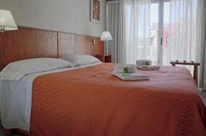 上格拉西亚努娜艾尼公寓的一张大床,上面有两条毛巾和两根蜡烛