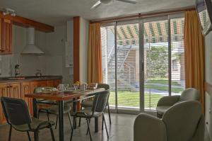 上格拉西亚努娜艾尼公寓的一个带桌椅和大窗户的厨房