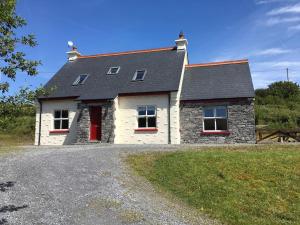 Fanore*Spacious Irish Cottage*的砂石车道上一扇红色门的房子