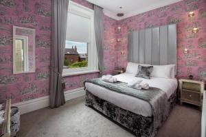 波尔顿乐法尔德布雷克公寓酒店的卧室配有粉红色的壁纸和床上的动物