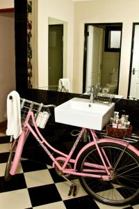 奥奇瓦龙戈Casa Forno Country Hotel的粉红色的自行车,浴室里设有水槽
