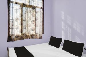吉申格尔OYO Flagship Aravali Guest House & Restaurant的客房设有床和带窗帘的窗户。