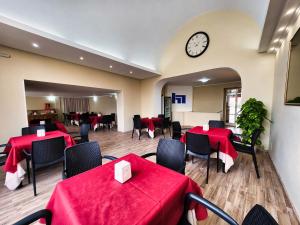 博尔塞纳国民酒店的餐厅设有红色的桌椅和时钟