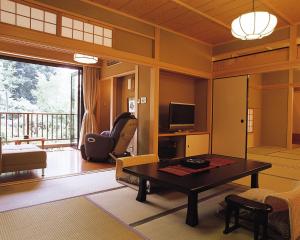 奈良春日酒店的客厅配有桌子和电视