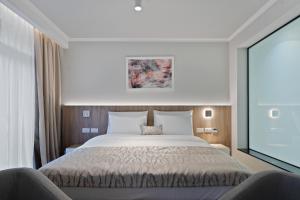 巴尼亚科维利亚查Hotel Podrinje的一间卧室配有一张大床和两把椅子