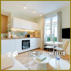 布洛涅-比扬古Suite Deluxe 2 by Les Maisons de Charloc Homes的客厅设有厨房和桌子