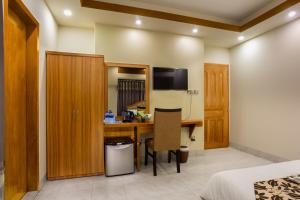 达卡Memento Suites an Airport Hotel的酒店客房设有书桌和卧室。
