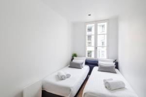 雷恩Appartements Le 31bis的带窗户的客房内的三张床