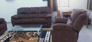 乌提Sandy Luxury 4 Bhk Villa的客厅配有两把椅子和一张沙发