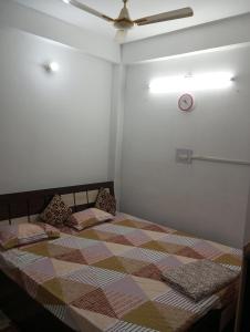 加雅Darbar Homestay的一间卧室配有一张大床和吊扇