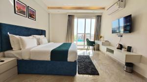 古尔冈AVA Hotels and Corporates Millennium City的一间卧室配有一张床、一张书桌和一台电视。
