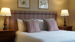 诺里奇The Red Lion Eaton的一间卧室配有一张带枕头的床和两盏灯。