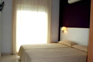 塞古德卡拉斐Hotel Sant Jordi的一间卧室设有一张床和一个大窗户