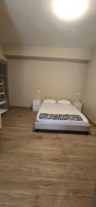 明德卢Apartamento Centro do Mindelo 6 min da praia的一间卧室配有一张床,铺有木地板