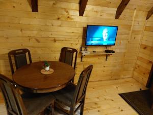 尼什Sicevacka Bajka的小屋内带桌子和电视的用餐室