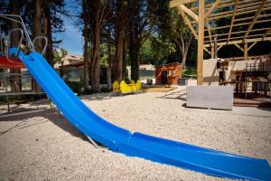 阿维尼翁Appartement de 2 chambres avec piscine partagee jacuzzi et jardin clos a Avignon的公园里一个带蓝色滑梯的游乐场