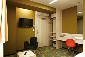 科希策罗卡国会酒店的一间设有两把椅子、一个水槽和镜子的房间