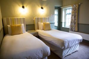 WhittingtonYe Old Boote Inn的一间客房内配有两张床的房间