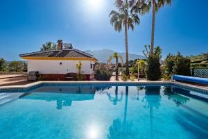 阿尔豪林格朗德Casa Amarilla Casitas的棕榈树屋前的游泳池