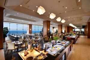济州市济州广场华美达酒店的一间带桌椅的海景餐厅