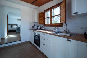 阿尔豪林格朗德Casa Amarilla Casitas的厨房配有白色橱柜和水槽