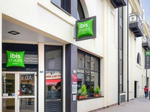 凯恩ibis Styles Caen Centre Historique的建筑物一侧有标志的商店