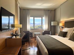 穆尔西亚Barceló Murcia Siete Coronas的酒店客房,配有一张床、一张桌子和椅子