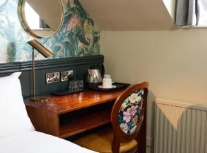 NarboroughNarborough Arms的一间卧室配有一张带镜子的桌子和一张床