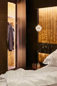 珀斯珀斯QT酒店的一间卧室设有床、窗户和一盏灯。