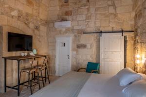 莱切Palazzo Sant'Anna Lecce的卧室配有一张床和一张桌子及椅子