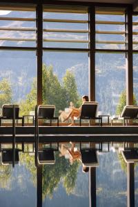 圣莫里茨圣莫里茨库尔姆酒店的坐在游泳池旁椅子上的女人
