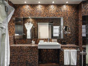 塔林塔林瑞士酒店的浴室设有水槽和镜子内的 ⁇ 