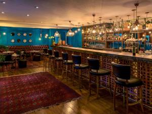 圣保罗Suíte 5 estrelas Hotel Moema Times Square 1412的一间酒吧,拥有蓝色的墙壁和酒吧凳子