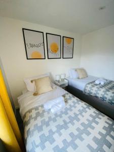 法恩伯勒Home in Farnborough with Free Parking, Wifi & Netflix的两张睡床彼此相邻,位于一个房间里