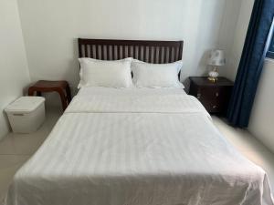 马尼拉Dreamy Sunset Bay的卧室配有一张白色的大床和床头柜。