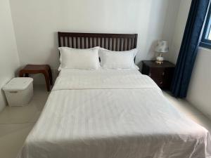 马尼拉Dreamy Sunset Bay的卧室配有白色的床和木制床头板