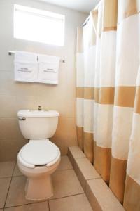 墨西卡利Hotel Boulevard Mexicali的一间带卫生间和淋浴帘的浴室