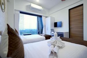 纳威孟买Gagal Home Navi Mumbai的酒店客房,配有两张带毛巾的床